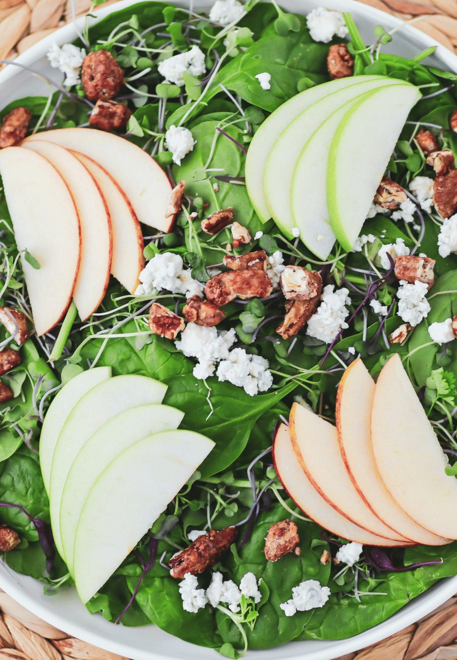 Bowl of salad greens with sliced apples, pecans and blue cheese