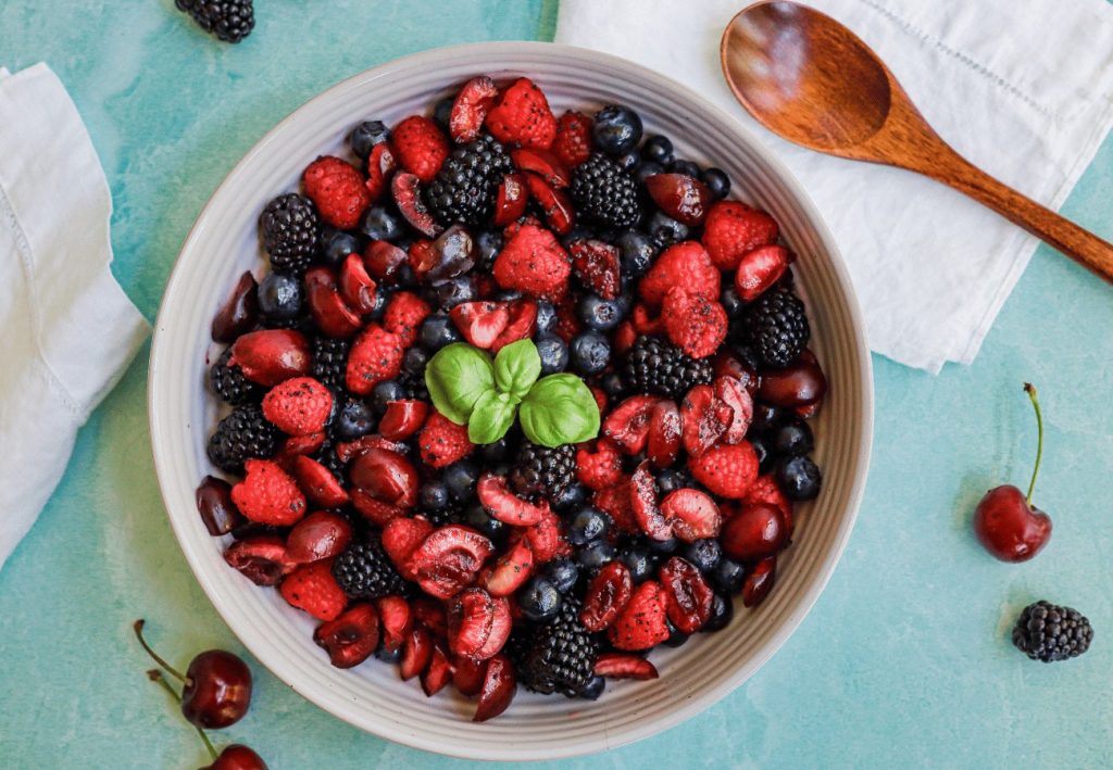 Bright fruit salad with raspberries, blackberries, cherries and blueberries