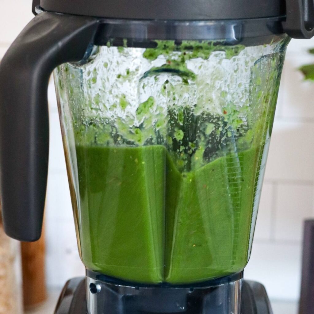 The blender jar filled with bright, fully emulsified green juice.